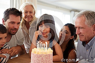 Three generation white family celebrating young girlï¿½s birthday with a cake and candles, close up Stock Photo